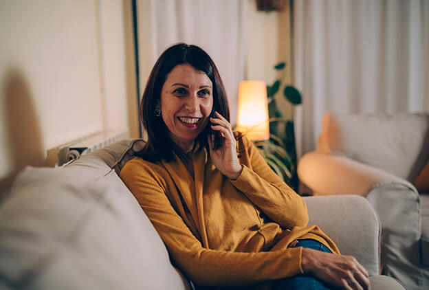 happy woman on couch on the phone