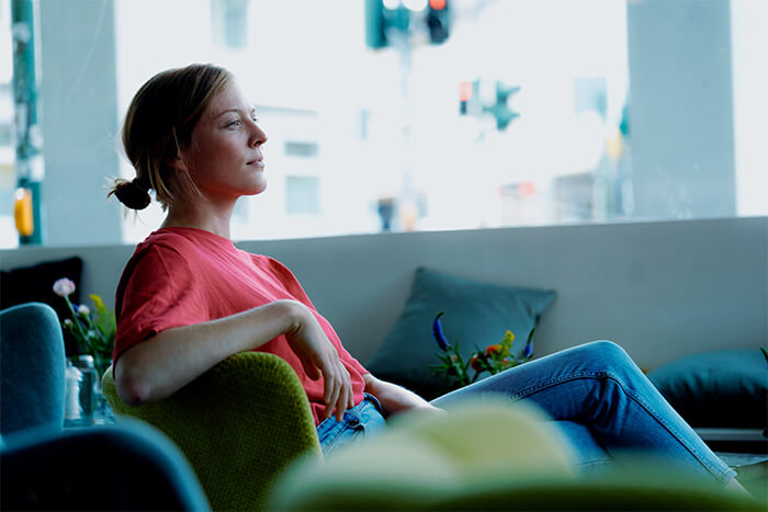 woman calmly sitting on couch watching tv